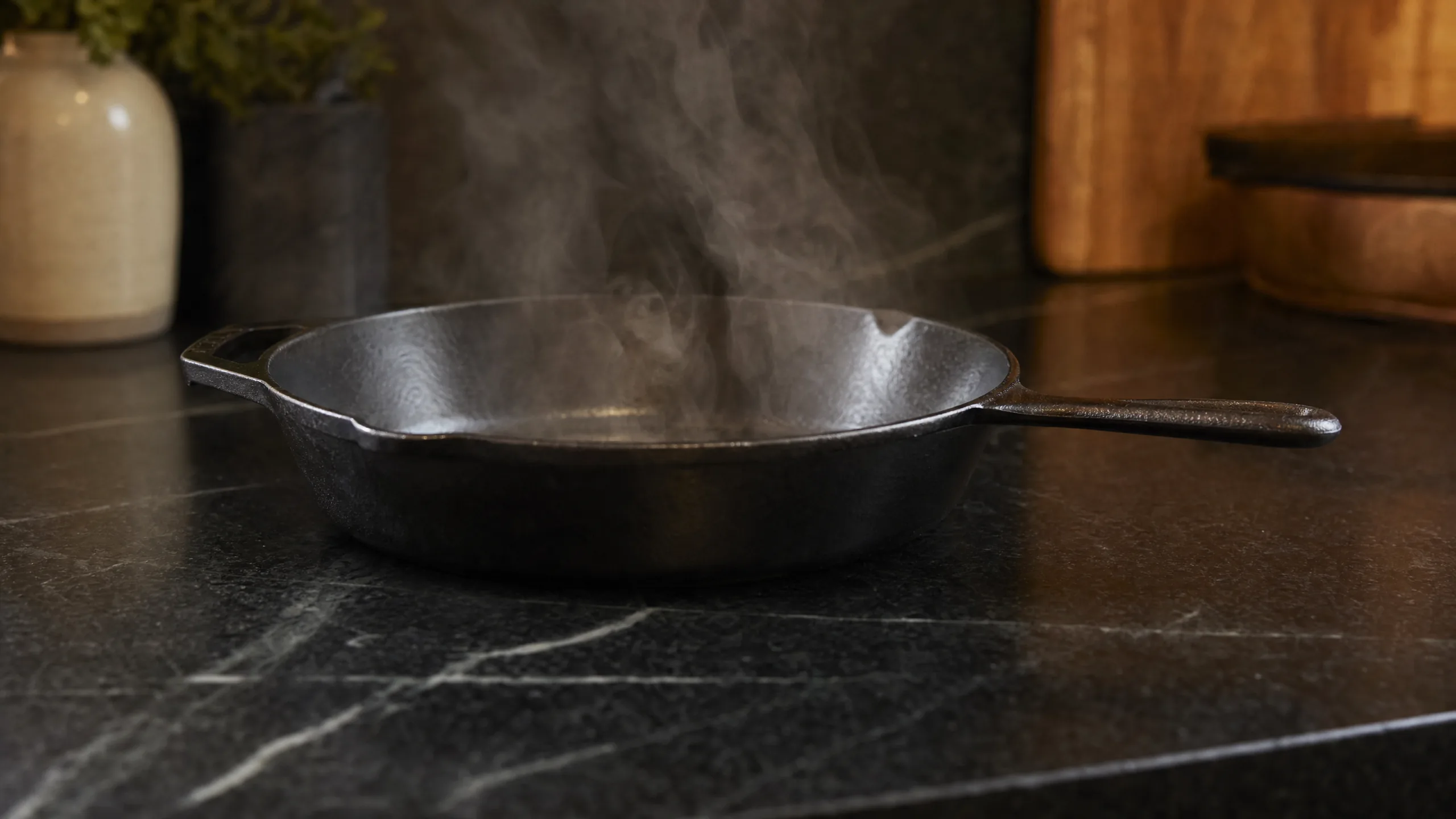 Cast iron skillet resting directly on a dark black granite countertop demonstrating granite heat resistance
