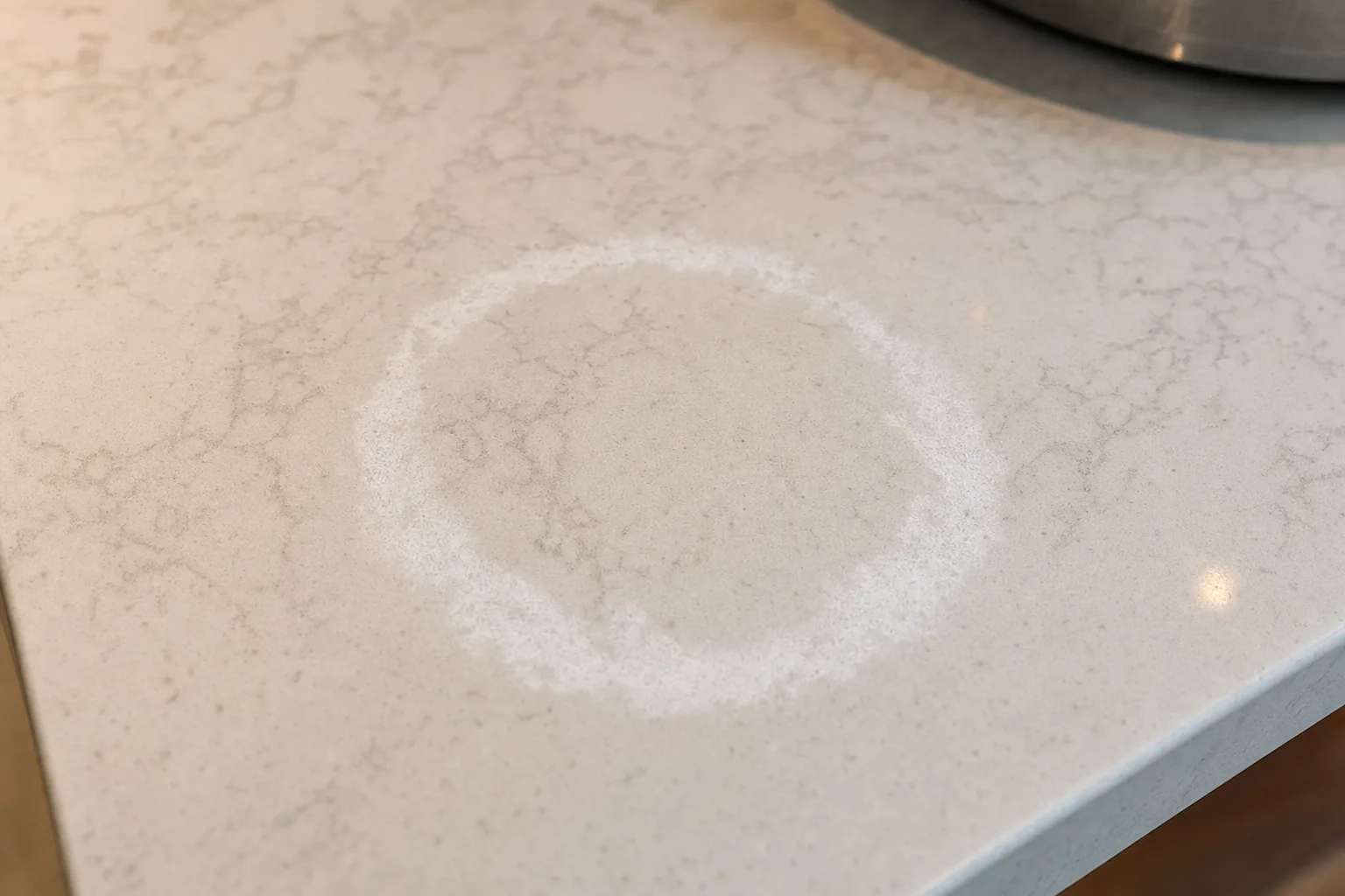 White quartz countertop showing thermal damage discoloration from a hot pan placed directly on the surface