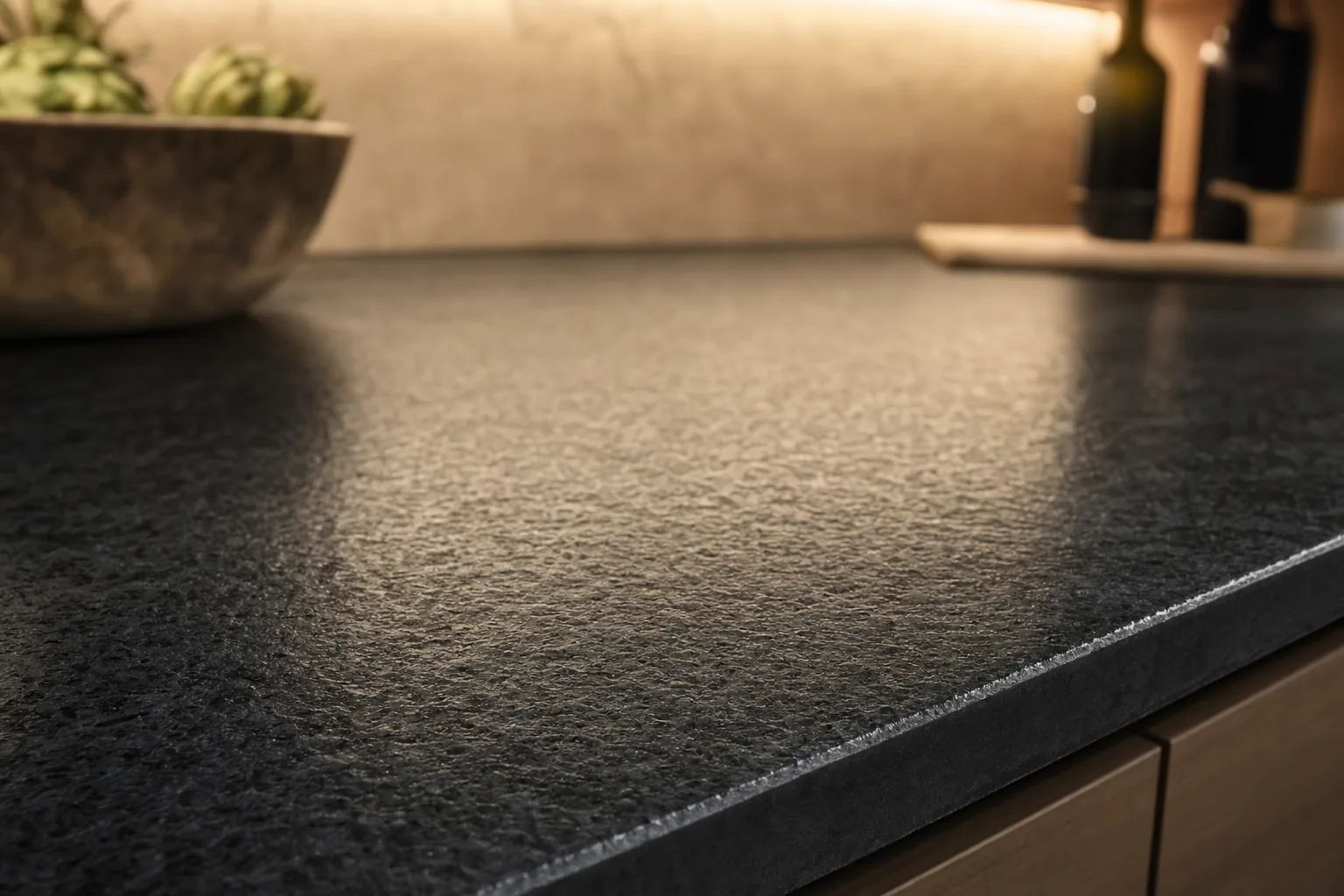 Close-up of a leathered dark granite countertop showing the distinctive matte textured finish